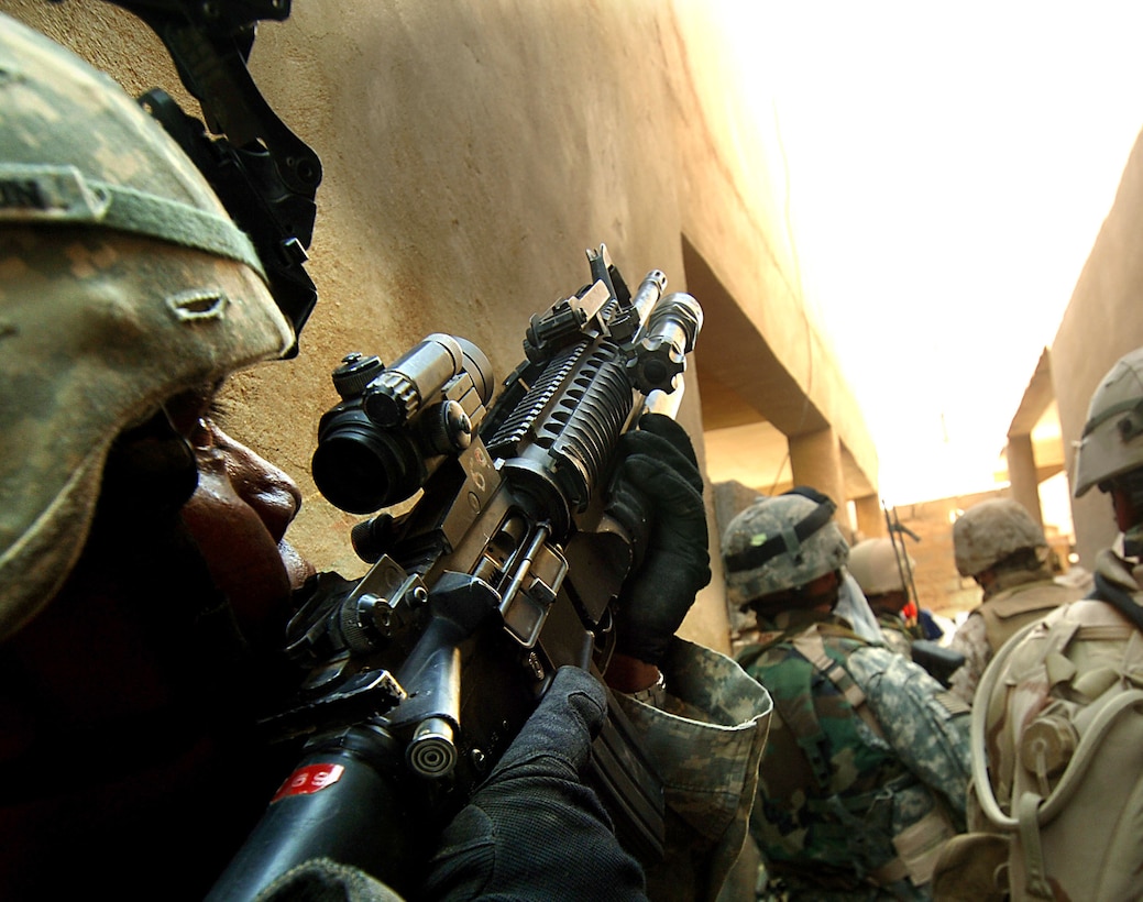 Soldiers from 1st Armored Division search for insurgents in houses located across street from Outpost 293 in Ramadi, Iraq, after mortar attack and gunfire were received on outpost July 24, 2006 (U.S. Air Force/Jeremy T. Lock)