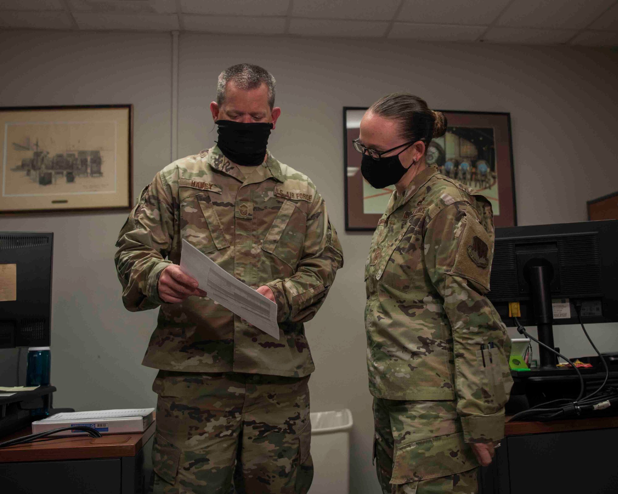 Senior Master Sgt. Christopher A. Haney and Master Sgt. Rebekah Schroeder look over a report at Joint Base Langley-Eustis, Virginia, July 22, 2020.
