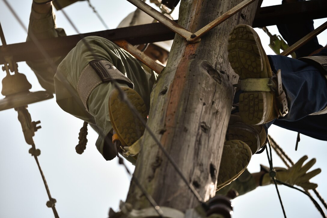 Tech. Sgt. Chaz Lineberger and Senior Airman Cody McCormick 8th Civil Engineer Squadron electrical systems technicians, prepare a line for reattachment in response to Typhoon Maysak at Kunsan Air Base, Republic of Korea, Sept. 3, 2020.