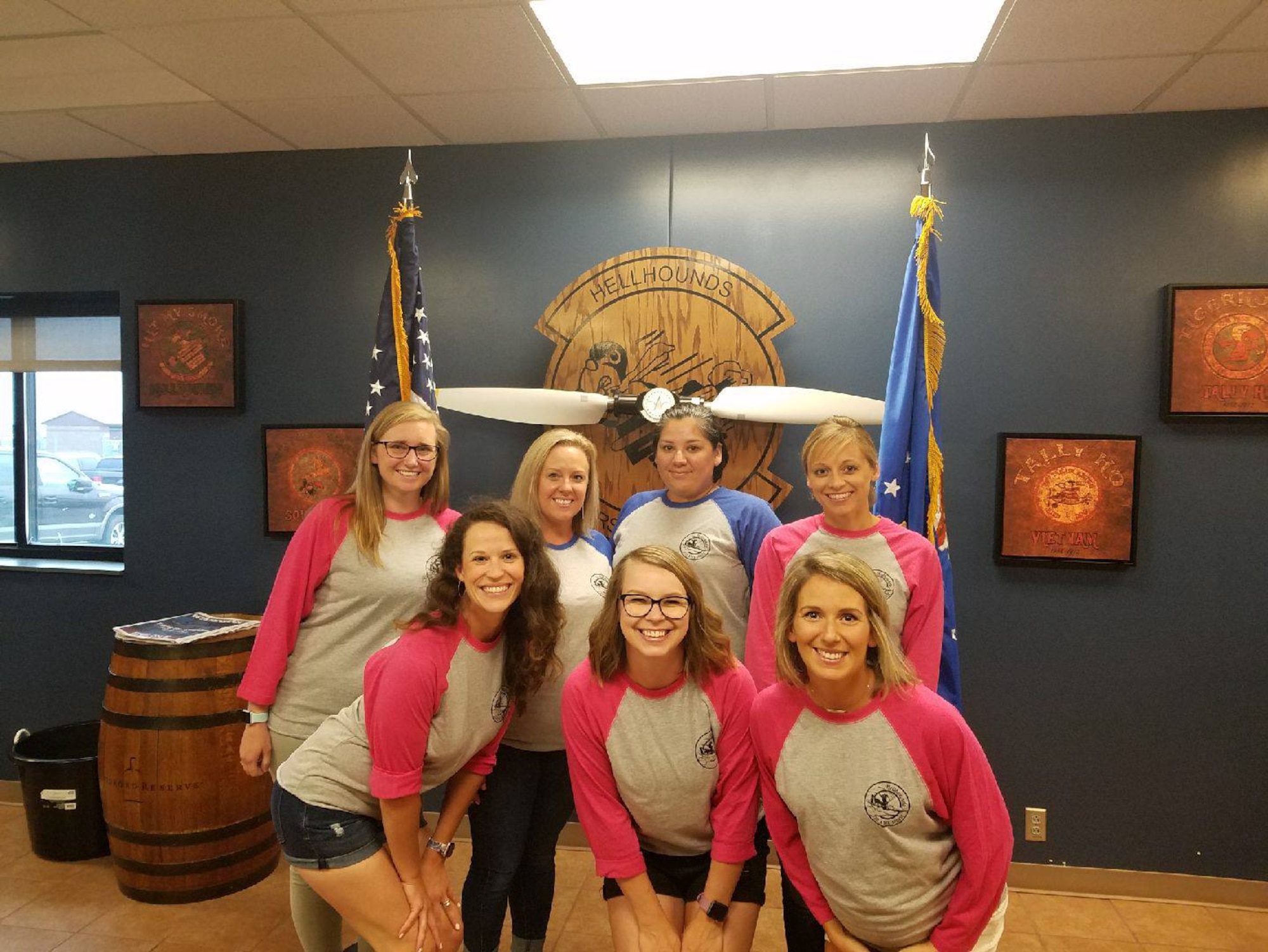 7 females spouses wearing matching squadron baseball shirts pose as a group while looking at the camera.