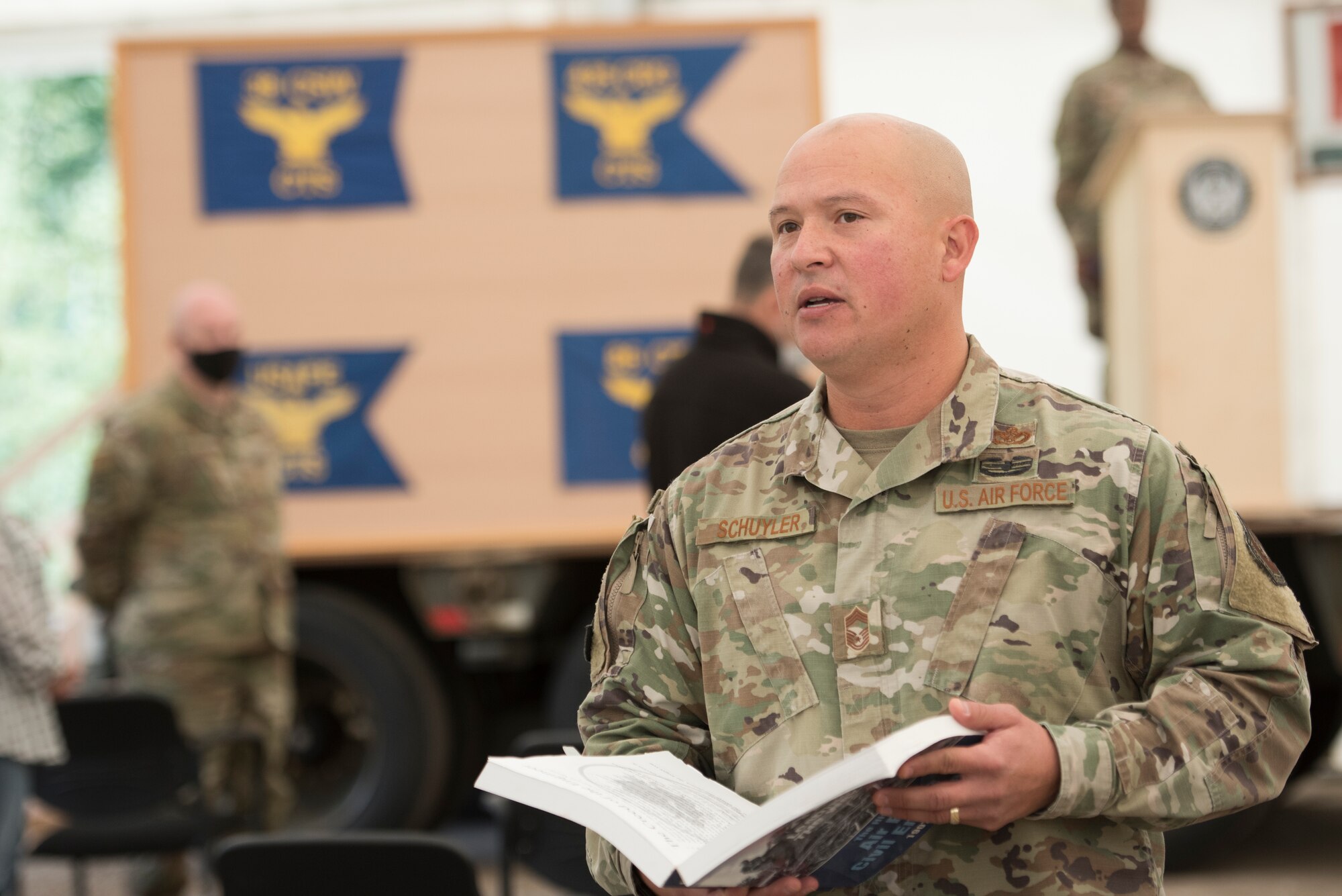 A photo of an Airman reading a creed from a book