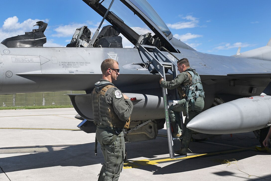 U.S. Air Force Staff Sgt. Devon Kercher, 31st Operations Support Squadron Radar Approach Control senior watch supervisor, climbs into a U.S. Air Force F-16 Fighting Falcon at Aviano Air Base, Italy, Sept. 3, 2020. Kercher took part in a familiarization flight on the F-16. (U.S. Air Force photo by Staff Sgt. Valerie Halbert)