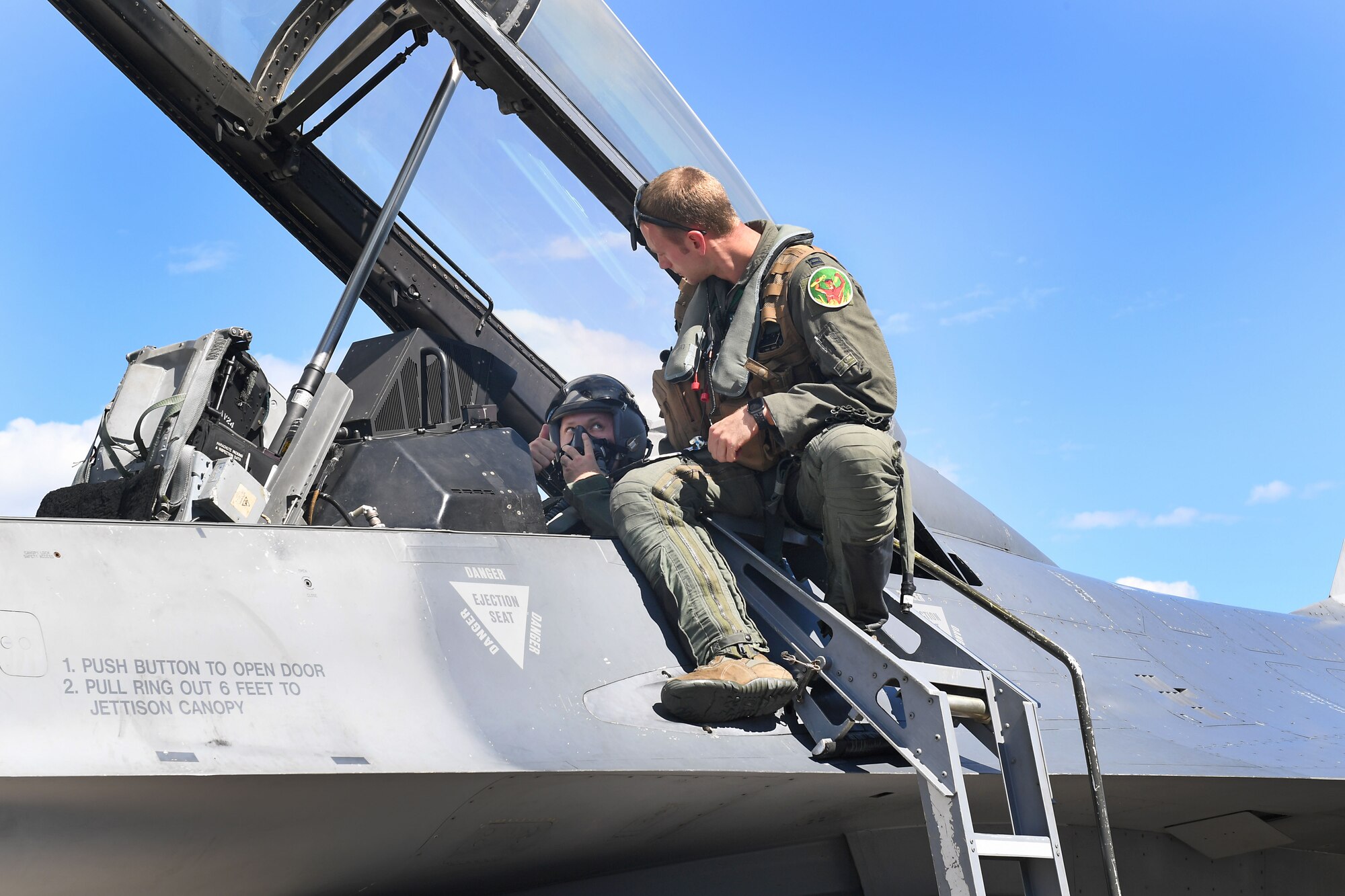 U.S. Air Force Staff Sgt. Devon Kercher, 31st Operations Support Squadron Radar Approach Control senior watch supervisor, is briefed by a U.S. Air Force F-16 Fighting Falcon pilot at Aviano Air Base, Italy, Sept. 3, 2020. Kercher was recently recognized as the 2019 U.S. Air Forces in Europe Air Traffic Controller of the Year and participated in a familiarization flight. (U.S. Air Force photo by Staff Sgt. Valerie Halbert)