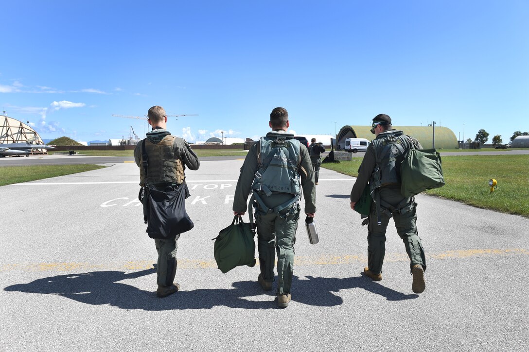 U.S. Air Force Staff Sgt. Devon Kercher, 31st Operations Support Squadron Radar Approach Control senior watch supervisor, center, walks across the flightline with U.S. Air Force F-16 Fighting Falcon pilots at Aviano Air Base, Italy, Sept. 3, 2020. Kercher took part in a familiarization flight on the F-16. (U.S. Air Force photo by Staff Sgt. Valerie Halbert)