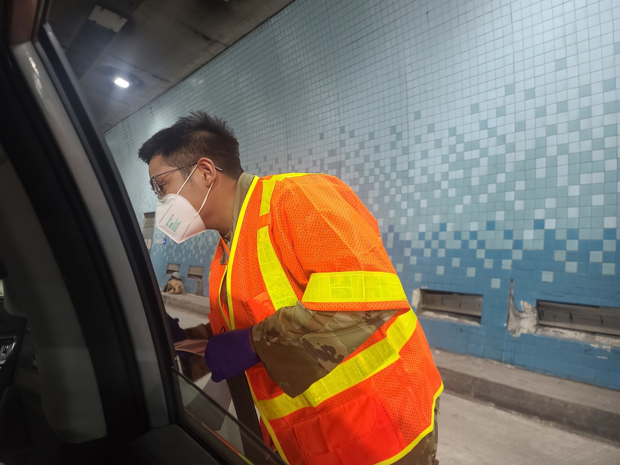 A member of Hawaii National Guard assigned to Joint Task Force Oahu supporting surge test registration at the Interstate H-3 assists leadership through registration requirements September 1, 2020, Honolulu, Hawaii. Guardsmen working the registration stations help and collect registration forms, and supply each testing passenger with his/her own COVID-19 test kit. The Hawaii National Guard (HING) Joint Task Force (JTF) assisted the City and County of Honolulu with their surge testing program from Aug. 26 through Sept. 14, 2020. U.S. Surgeon General, Dr. Jerome Adams and Honolulu County Mayor Kirk Caldwell coordinated multiple locations for about 60,000 tests with an ambitious goal of conducting 5,000 tests daily on the island of Oahu. (U.S. Army National Guard photo by 1LT Anyah Peatross)