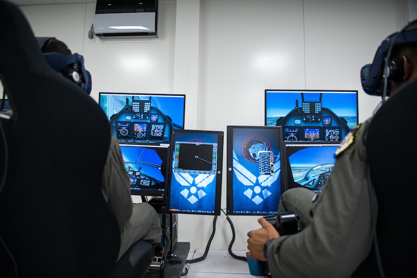 Airmen operate an aircraft simulator.