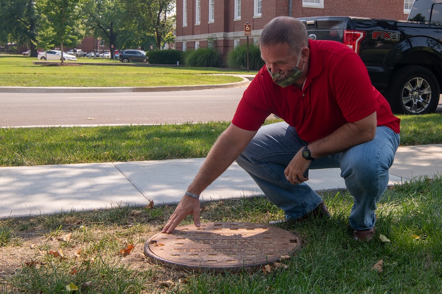 Man inspects manhole cover