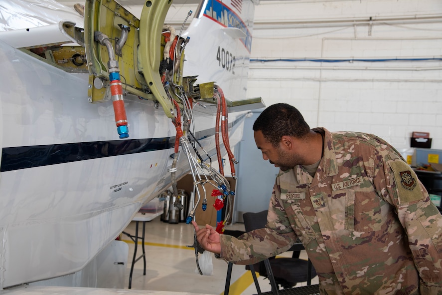 Man inspect aircraft fuel lines.