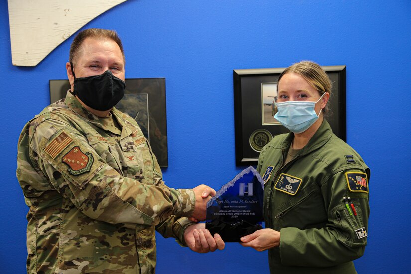 Alaska Air National Guard Capt. Natasha Sanders, an HC-130 Combat King II pilot with the 211th Rescue Squadron, receives the Company Grade Officer of the Year award from Director of Staff Col. John Oberst at Hangar 18 on Joint Base Elmendorf-Richardson Aug. 28, 2020. She was recognized for her 2019 accomplishments that included a successful rescue operation that saved the lives of three Alaska citizens. (U.S. Army National Guard photo by Sgt. Seth LaCount/Released)