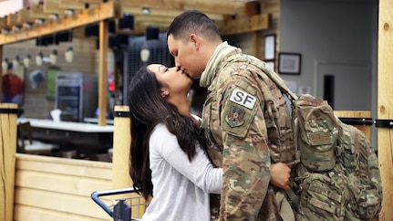 Airman 1st Class Kevin Waters an Alaska Air Guardsman with the 176th Security Forces Squadron shares a loving moment with his partner at Ted Stevens-Anchorage International Airport upon his return from Kandahar, Afghanistan on June 22, 2020. 12 AKNG Airmen deployed in support of Operation Freedom Sentinel, a NATO-led continuation of the Global War on Terrorism. (U.S. Air National Guard photo by Lt. Col. Candis Olmstead/Released)