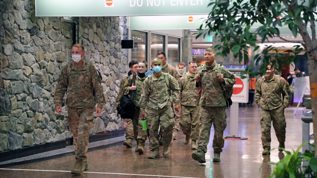 Alaska Air National Guardsmen assigned to the 176th Security Forces Squadron, walk through Ted Stevens-Anchorage International Airport upon returning from an 8-month deployment in Kandahar, Afghanistan, June 23, 2020. The unit executed air base defense in support of Operation Freedom Sentinel, NATO-led continuation of the Global War on Terrorism. (U.S. Air National Guard photo by Lt. Col. Candis Olmstead/Released)