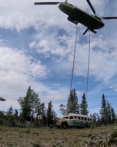 Alaska Army National Guard Soldiers assigned to 1st Battalion, 207th Aviation Regiment execute an extraction mission via a CH-47 Chinook helicopter over Healy, Alaska, June 18, 2020. As part of a combined effort with the Department of Natural Resources, the Guardsmen rigged and airlifted “Bus 142”,, an historic icon from book and film, “Into the Wild”, out of its location on Stampede Road in light of public safety concerns. The bus will be stored at a secure site while the DNR considers all options and alternatives for its permanent disposition. (Alaska National Guard courtesy photo)