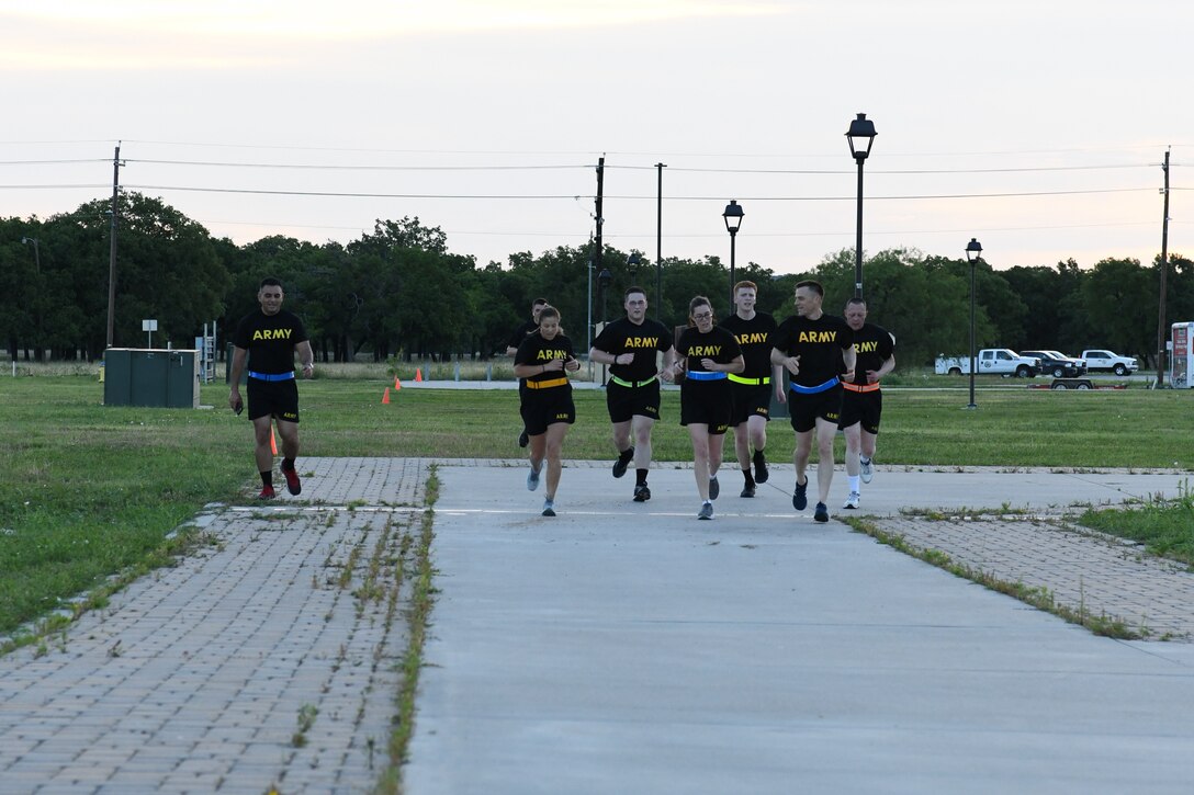 Alaska Army National Guard Staff Sergeant Bethany Hendren completes her 100 mile challenge at Fort Hood, Texas, May 22, 2020. She is surrounded by her Guard family members from the 297th Regional Support Group as she prepares for mobilization to Poland later this year. (U.S. Army National Guard Photo by SGT Heidi Kroll)