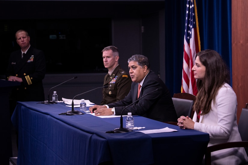 Three people sit at a table.