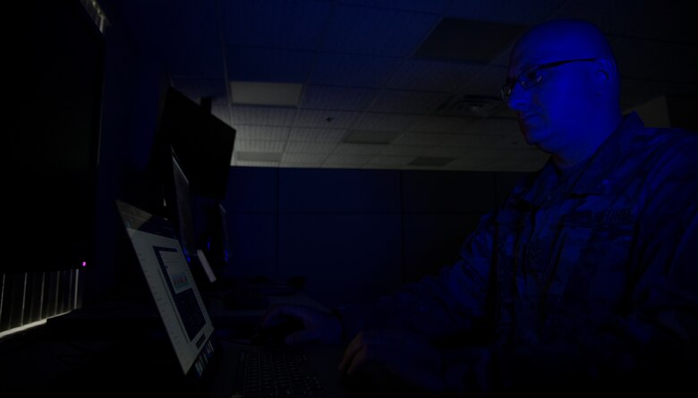 Airman looks at computer screen