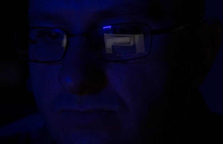 Airman looks at computer screen