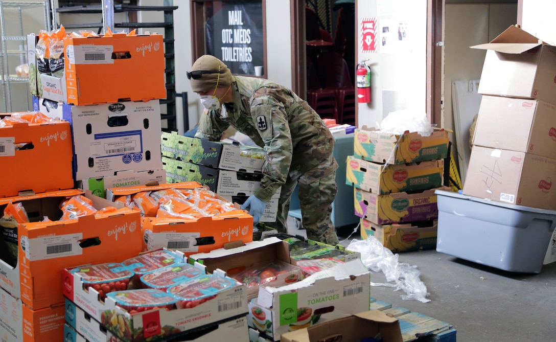 Alaska Army National Guard Soldier Sgt. Kekoa Maclovesramirez stacks boxes of food donated from local Alaskan food banks at Beans Cafe in Anchorage, Alaska, Apr. 8, 2020. Amid the COVID-19 pandemic, Alaska National Guard Soldiers have taken the weight of the load for much needed volunteer hours at Beans Cafe, that feeds thousands of local Alaskans in the Anchorage area. (U.S Army National Guard photo by Sgt. Seth LaCount/Released)