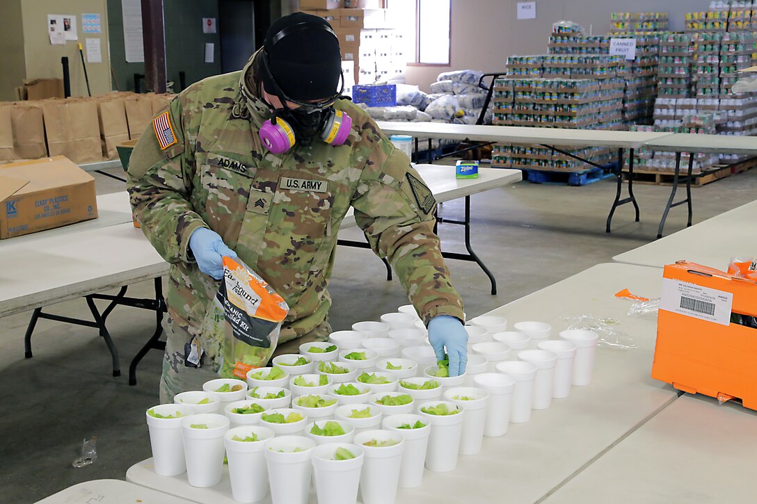Alaska Army National Guard Soldier Sgt. Zach Adams prepares mini salad kits with fresh produce for pre-packed lunches at Bean's Cafe in Anchorage, Alaska, Apr. 8, 2020. Soldiers assigned to the AKARNG's Recruiting and Retention Battalion have been working tirelessly at the non profit organization to mitigate the toll that the COVID-19 pandemic has taken on Bean's volunteer workforce, who is responisble for feeding more than 1000 local Alaskans per day. (U.S. Army National Guard photo by Sgt. Seth LaCount/Released)
