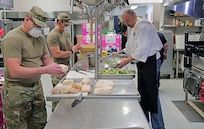 Alaska Army National Guard Soldiers Sgt. David Osmanson and Staff Sgt. Edward Jones, assigned to the AKARNG Recruiting and Retention Battalion work alongside Bean's Cafe employees, creating pre-packed lunches in the kitchen at Bean’s Cafe in Anchorage, Alaska, Apr. 8, 2020. This food will be distributed to thousands of local Alaskans sheltering at Sullivan and Boeke arenas as well as the Alaska After School Lunch program. (U.S. Army National Guard photo by Sgt. Seth LaCount/Released)