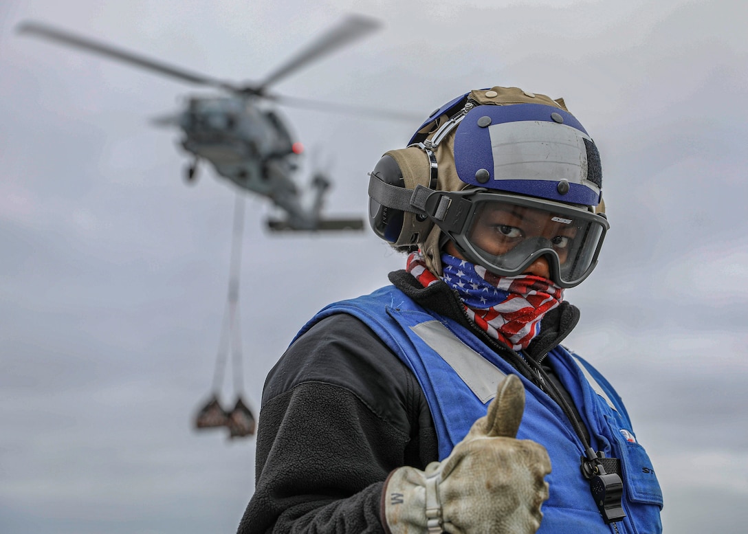 Aviation boatswain’s mate (handling) 3rd class Tainesha Hines shows encouragement on flight deck during vertical replenishment onboard amphibious assault ship USS Makin Island, Pacific Ocean, April 20, 2020 (U.S. Navy/Harry
Andrew D. Gordon)