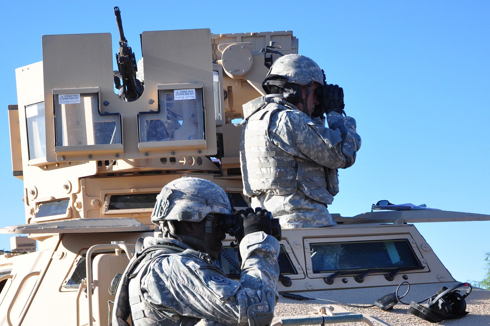 Soldiers look through binoculars.