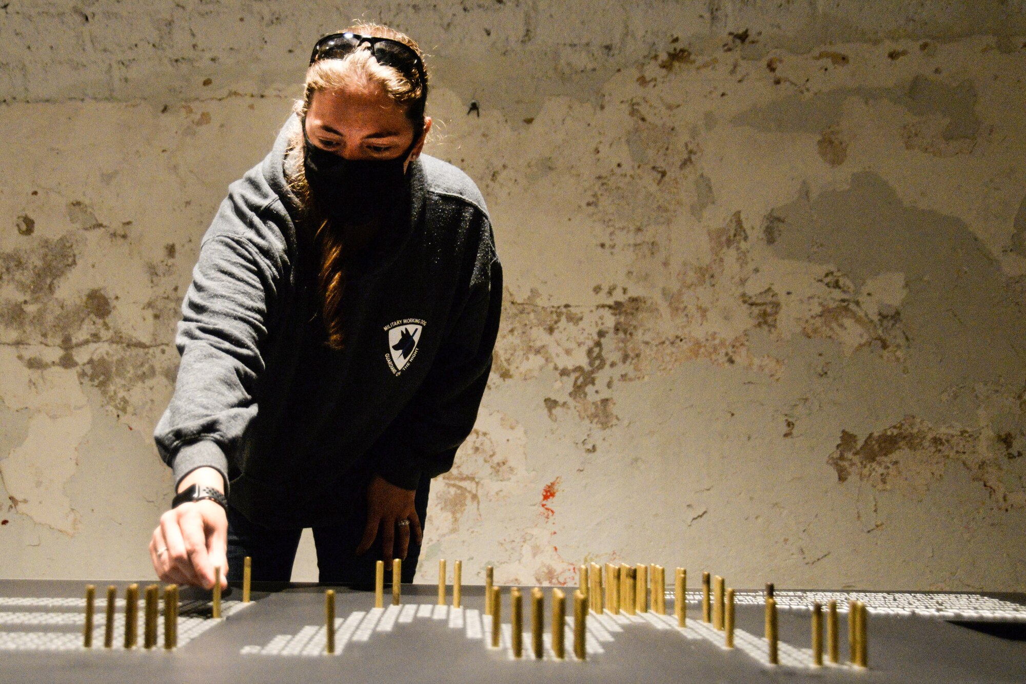 U.S. Air Force Staff Sgt. Lisa Kiesewetter, 86th Security Forces Squadron military working dog trainer, places a bullet casing in the exhibit at former U.S. Army Ordnance Depot Maßweiler, Germany, Sept. 4, 2020. Each bullet casing pays tribute to animals who gave the ultimate sacrifice for their country. (U.S. Air Force photo by Tech. Sgt. J. Smith)