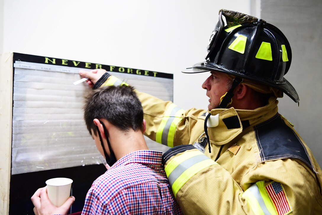 U.S. Air Force Col. John Gonzales, 51st Fighter Wing commander, places names of those who lost their lives during 9/11 on a remembrance board at Osan Air Base, Republic of Korea, Sept. 11, 2020. Patriot Day commemorates the men and women who lost during the 9/11 attacks and in battles against Al-Qaeda which followed. (U.S. Air Force photo by Senior Airman Noah Sudolcan)