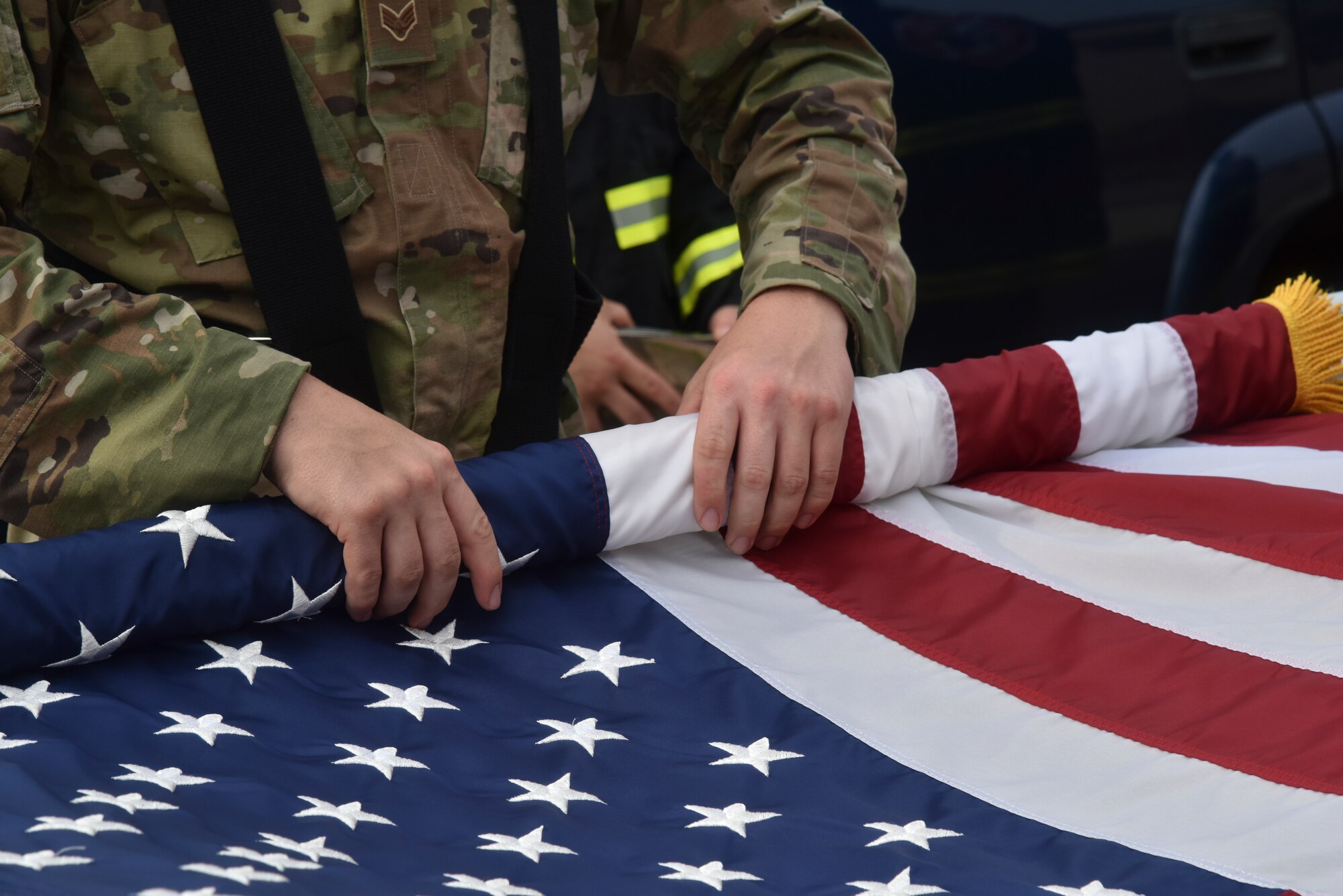 An honor guardsman rolls the American Flag after a 9/11 memorial service on Kunsan Air Base, Republic of Korea.