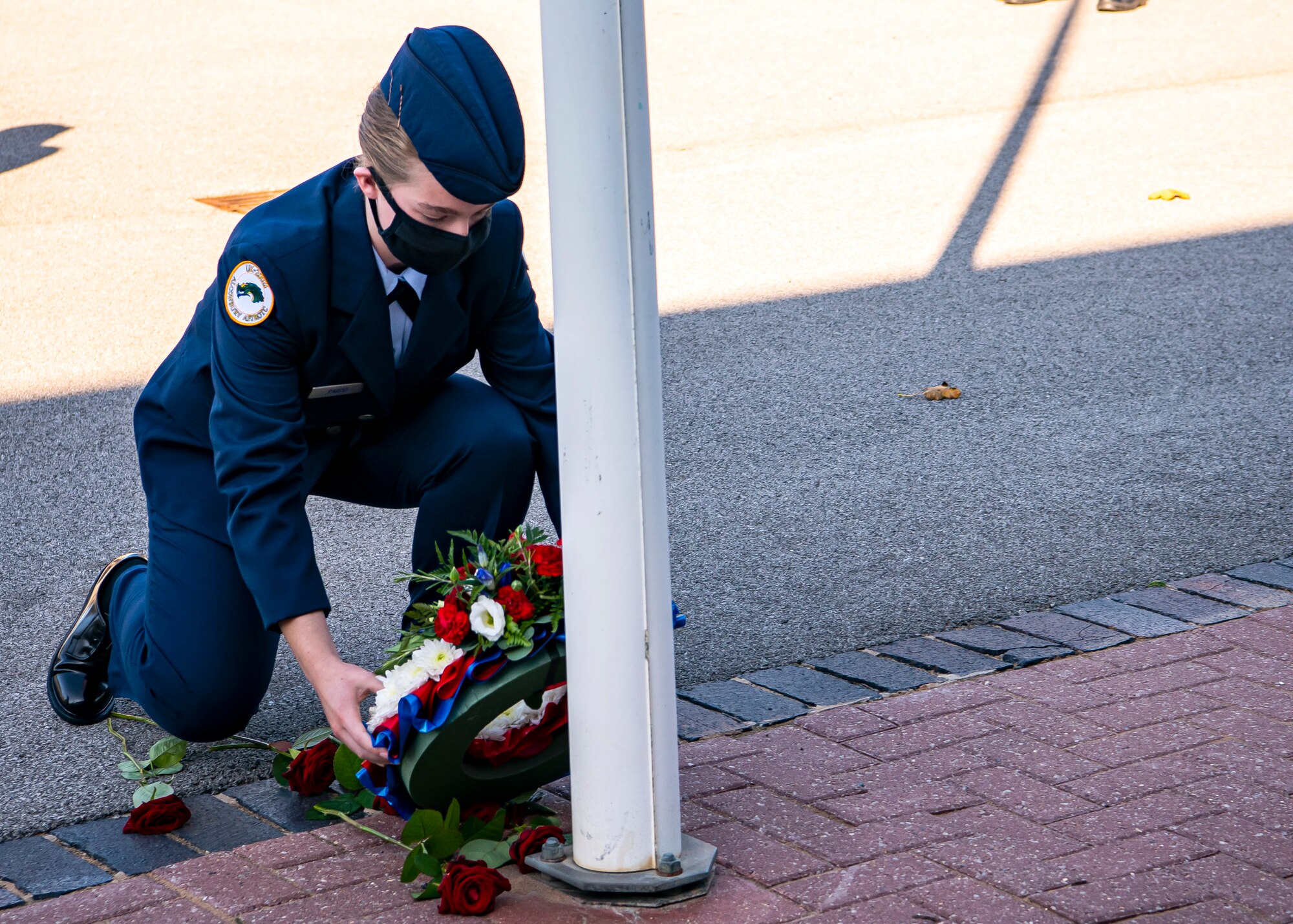 Emily Pardo, Alconbury High School JROTC cadet, places a wreath next to a flagpole during a 9/11 remembrance ceremony at RAF Alconbury, England, Sep. 9, 2020. Cadets along with Airmen from the 501st Combat Support Wing participated in the ceremony to honor those who lost their lives during the September 11th terrorist attacks. (U.S. Air Force photo by Senior Airman Eugene Oliver)