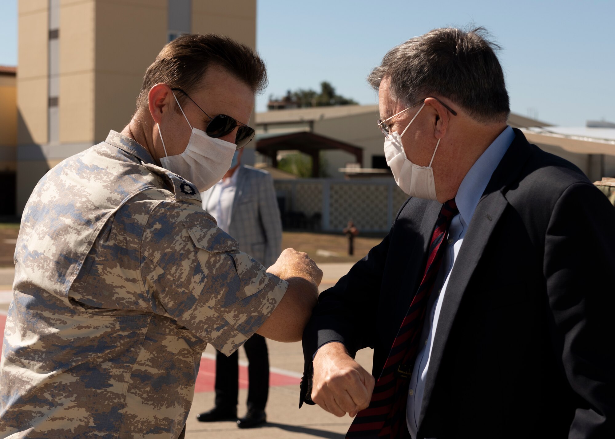 A Turkish Air Force colonel and the U.S. Ambassador to Turkey bump elbows in greeting while wearing face masks.
