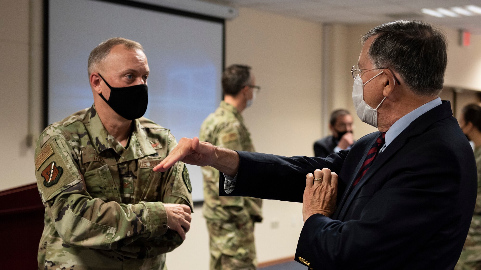 Col. John Creel, 39th Air Base Wing commander, and U.S. Ambassador to Turkey David Satterfield talk about strategy with hand gestures and from behind face masks.