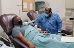 Richard Rangel, medical laboratory technician, prepares Thefety Tibbs, who was among the first donors of convalescent plasma, for his first convalescent plasma donation in June 2020 at the Akeroyd Blood Donor Center at Joint Base San Antonio-Fort Sam Houston.