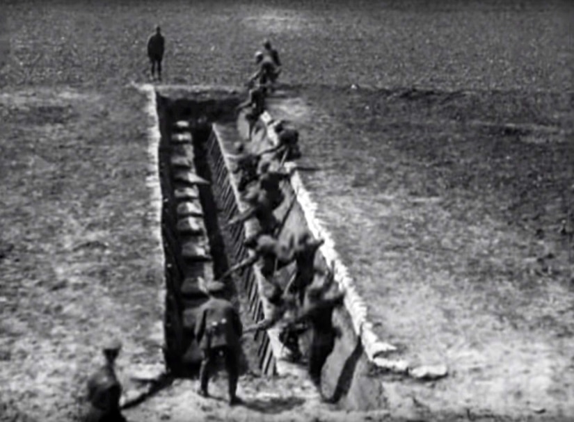 Men stand in a large man-made trench.