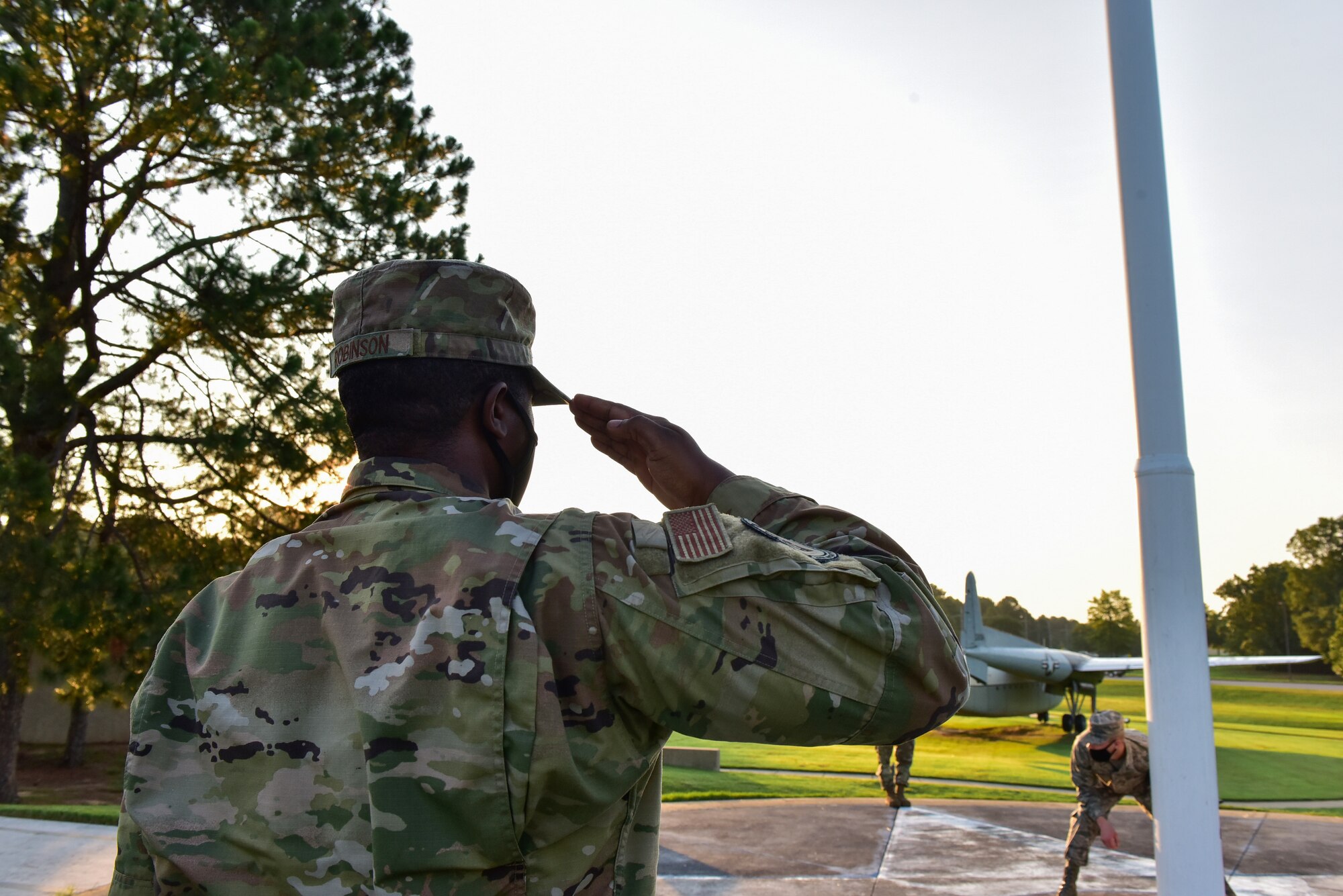 An Airman salutes the flag