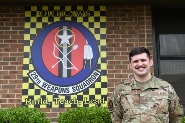 A man stands in front of a building.