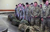 Alaska Army National Guard Soldiers assigned to 1st Battalion, 297th Infantry Regiment eagerly wait for their luggage to arrive after flying into Ted Stevens Anchorage International Airport Apr. 4, 2020. The Soldiers returned from a 9 month deployment to Kosovo for a NATO peacekeeping mission. (U.S. Army National Guard photo by Sgt. Seth LaCount/Released)