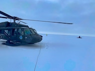 An Alaska Army National Guard UH-60 Black Hawk helicopter sits on packed snow about 25 miles east of Nome, Alaska, during a search and rescue mission for three Iditarod mushers March 20, 2020. The mushers and their dogs went through Bering Sea flood waters on the race trail and were wet and freezing. The aircrew transported two firefighter emergency medical technicians and Iditarod dog handlers to assist. The mushers were flown to Nome and transported to a local hospital. A local search and rescue team helped race dog handlers care for the sled team and returned them to Nome. (Courtesy photo)