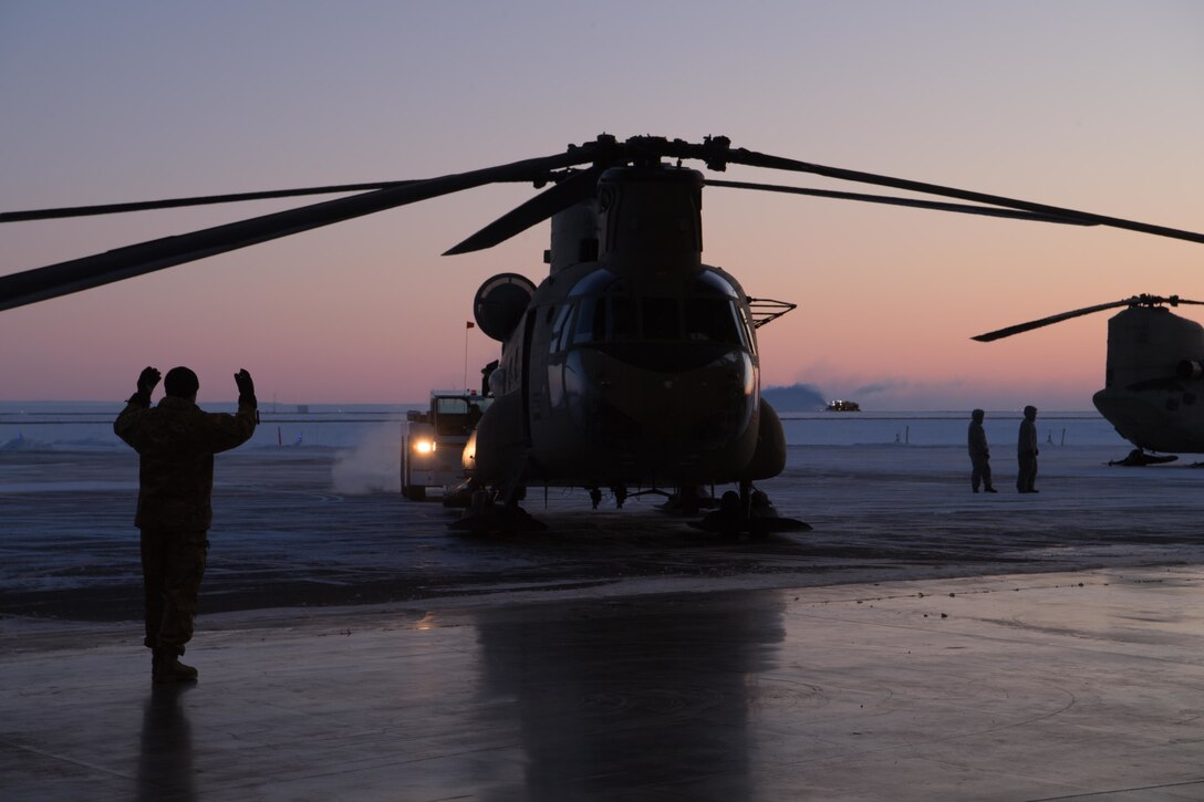U.S. Soldiers with the Alaska Air National Guard assigned to the 2nd Battalion, 211th Aviation Regiment, help navigate CH-47 Chinooks into a hangar at Deadhorse, Alaska, Feb. 24, 2020. The Alaska National Guard is hosting Exercise Arctic Eagle 2020, a joint-training exercise, Feb. 20 to March 6, 2020, throughout Alaska, including Joint Base Elmendorf-Richardson, Eielson Air Force Base, Fort Wainwright, the Yukon-Kuskokwim Delta and as far north as Teshekpuk Lake. As a homeland security and emergency response exercise, Arctic Eagle 20 is designed to increase the National Guard’s ability and effectiveness to operate in the extreme cold-weather conditions found in Arctic environments. (U.S. Air Force photo by Tech. Sgt. Amy Picard)