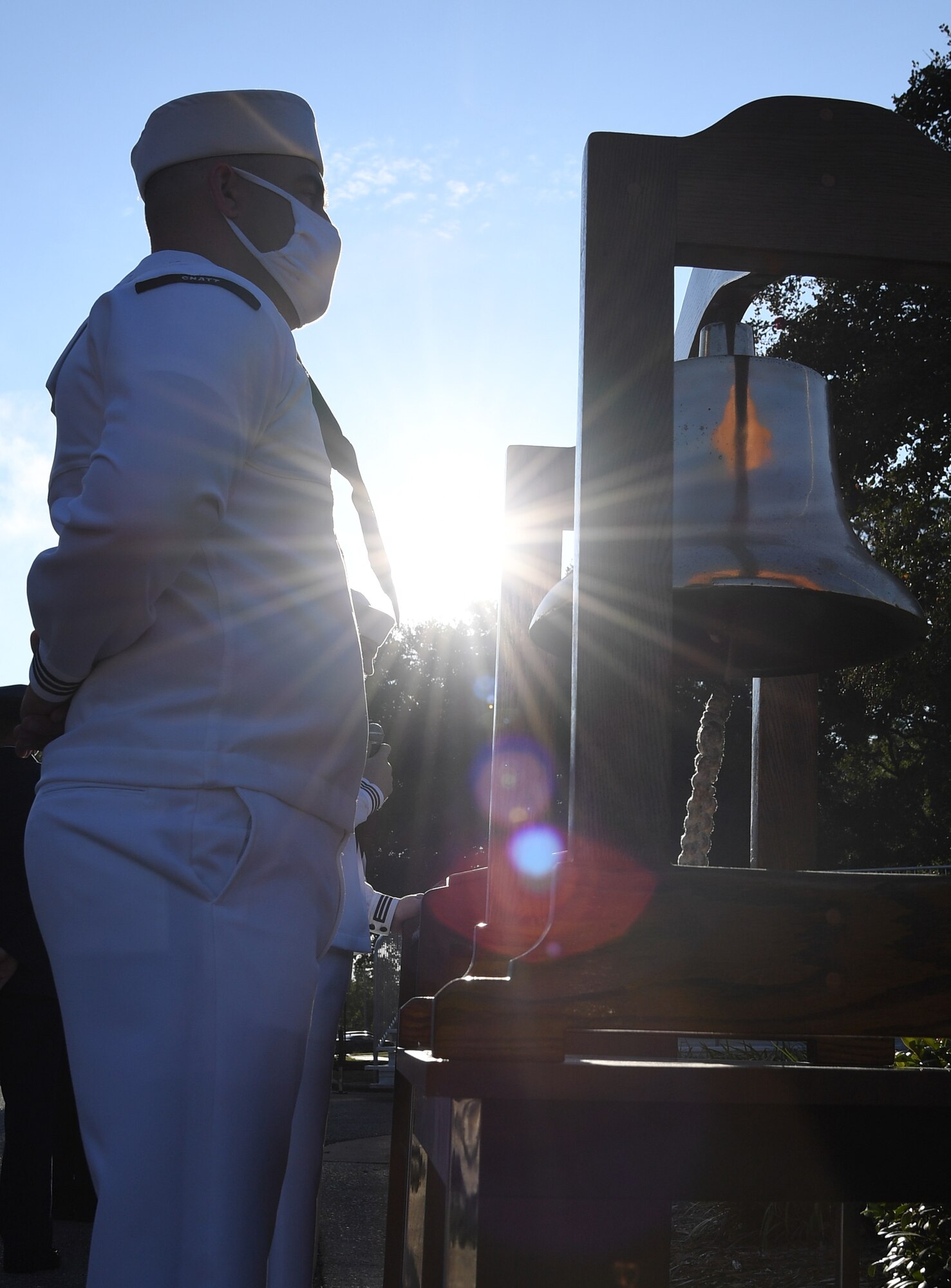 U.S. Navy Aerographers Mate 1st Class Ryan Gilroy, Center for Naval Aviation Technical Training Unit Keesler instructor, stands next to the bell during a 9/11 memorial ceremony hosted by the CNATTU Keesler in front of the 81st Training Wing headquarters building at Keesler Air Force Base, Mississippi, Sept. 11, 2020. The event honored those who lost their lives during the 9/11 attacks. (U.S. Air Force photo by Kemberly Groue)