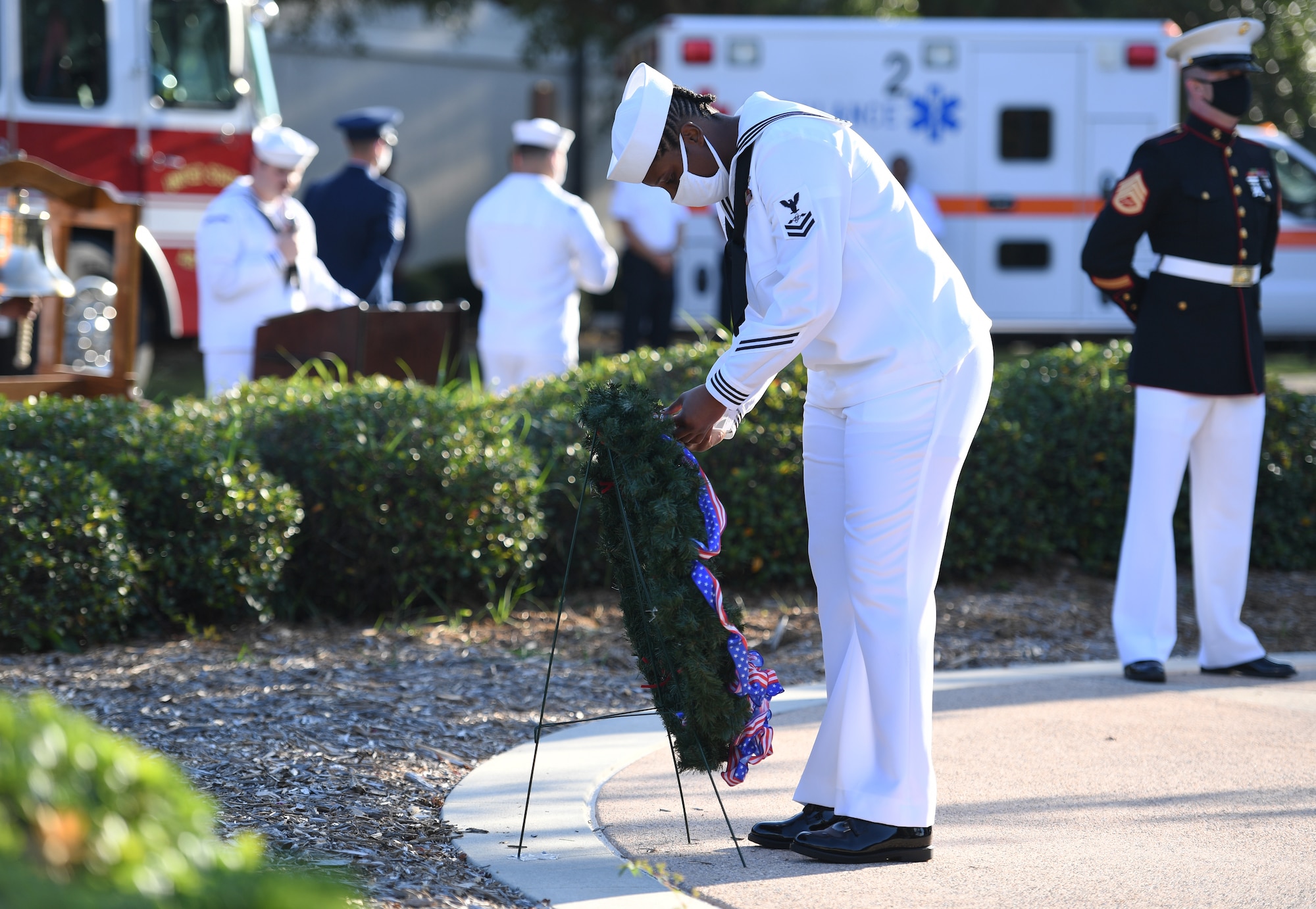 U.S. Navy Aviation Electronics Technician 2nd Class Joncherie Woodard, Center for Naval Aviation Technical Training Unit Keesler instructor, places a photo identification card of a military member who lost their life in the 9/11 attacks during a 9/11 memorial ceremony hosted by the CNATTU Keesler in front of the 81st Training Wing headquarters building at Keesler Air Force Base, Mississippi, Sept. 11, 2020. The event honored those who lost their lives during the 9/11 attacks. (U.S. Air Force photo by Kemberly Groue)