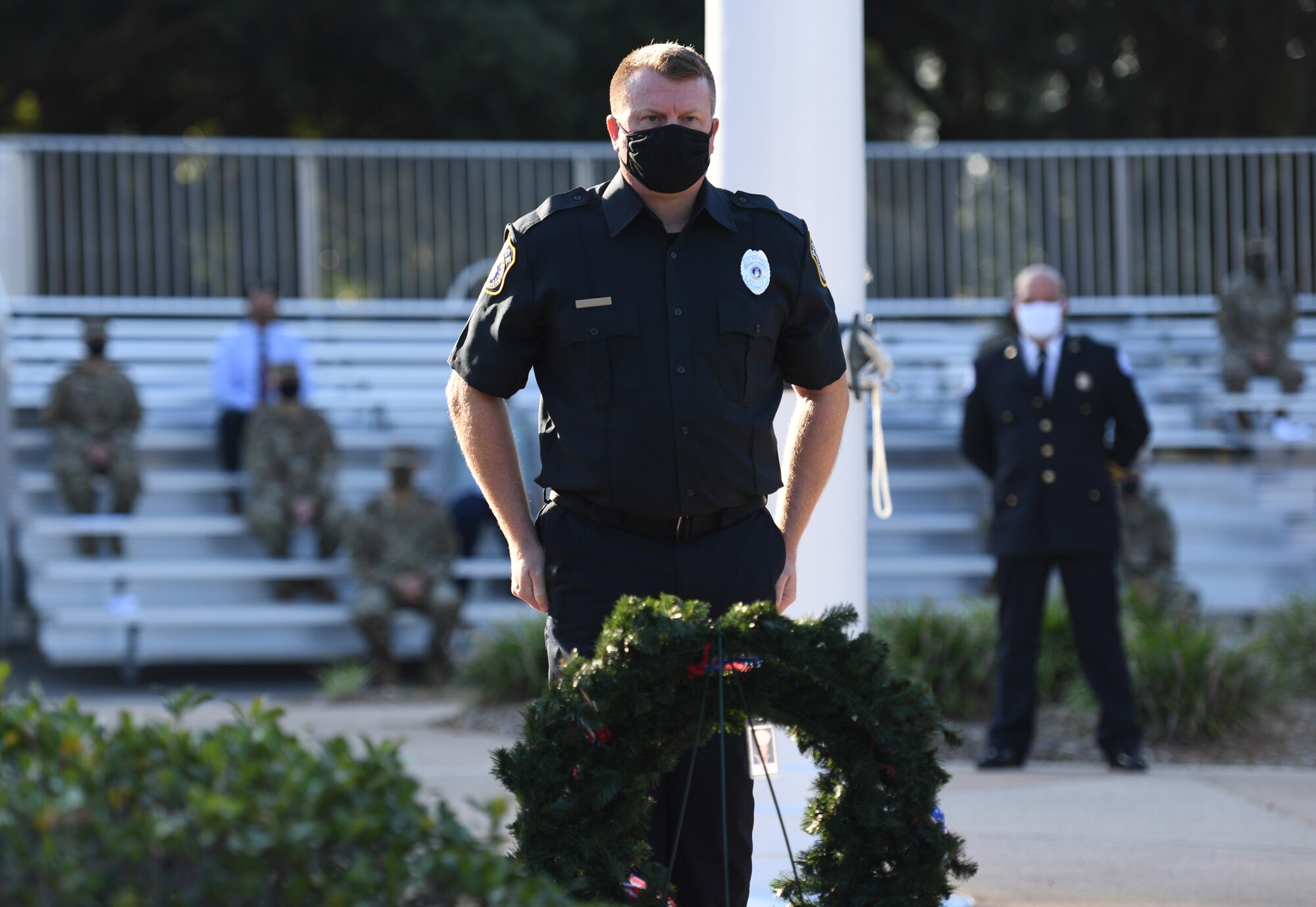 Jeffery Williams, 81st Security Forces Squadron patrolman, prepares to place a photo identification card of a military member who lost their life in the 9/11 attacks during a 9/11 memorial ceremony hosted by the Center for Naval Aviation Technical Training Unit Keesler in front of the 81st Training Wing headquarters building at Keesler Air Force Base, Mississippi, Sept. 11, 2020. The event honored those who lost their lives during the 9/11 attacks. (U.S. Air Force photo by Kemberly Groue)