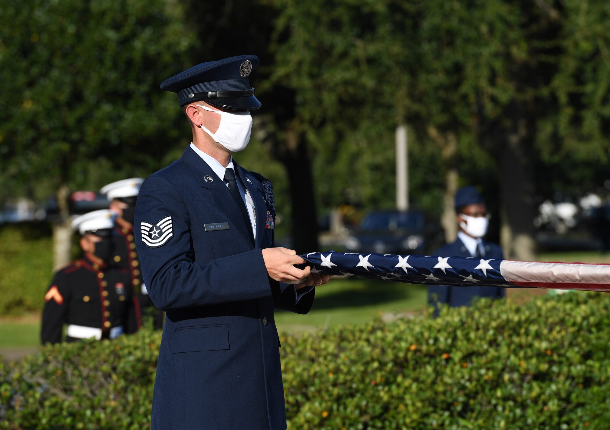 U.S. Air Force Tech. Sgt. Landon Spaulding, 81st Training Support Squadron military training leader, unfolds the U.S. flag during a 9/11 memorial ceremony hosted by the Center for Naval Aviation Technical Training Unit Keesler in front of the 81st Training Wing headquarters building at Keesler Air Force Base, Mississippi, Sept. 11, 2020. The event honored those who lost their lives during the 9/11 attacks. (U.S. Air Force photo by Kemberly Groue)