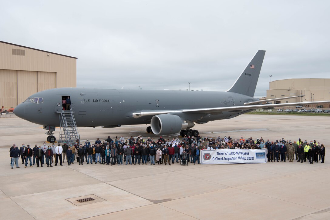 Gray airplane with group of people in front