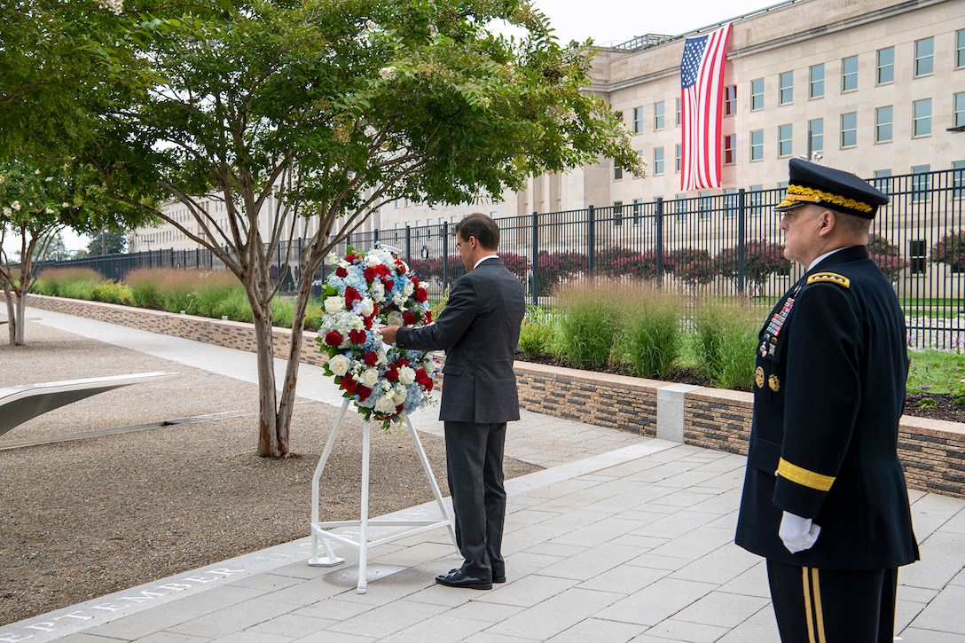 Defense Secretary Dr. Mark T. Esper places a wreath outside the Pentagon as Army Gen. Mark A. Milley stands nearby.