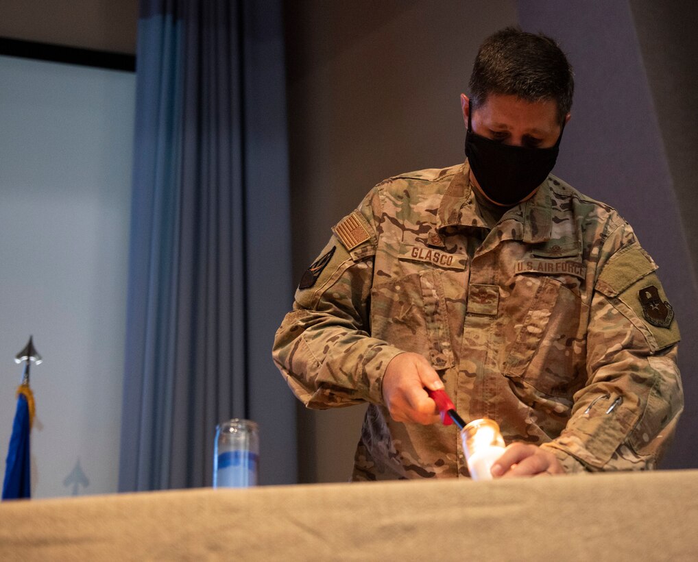 Col. Ted Glasco, 47th Mission Support Group commander, lights a white candle at the 9/11 Remembrance Ceremony on Sept. 11, 2020 at Laughlin Air Force Base, Texas. The white candle symbolizes the families who were touched by the 9/11 terrorist attacks.