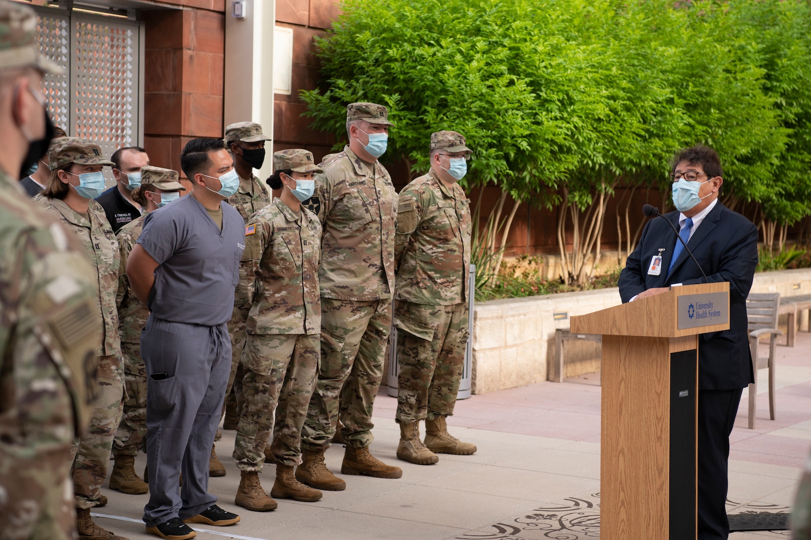 Man speaks to a group of Soldiers.