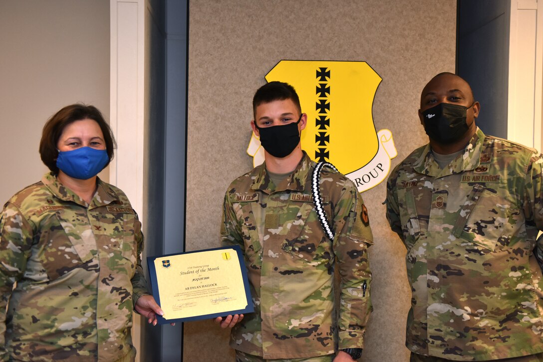 U.S. Air Force Col. Angelina Maguinness, 17th Training Group commander, and Chief Master Sgt. Charmane Tatum, 17th TRG superintendent, present Airman Dylan Hallock, 312th Training Squadron student, with his award. The 312th TRS’ mission is to provide Department of Defense and international allies with mission ready fire protection and special instruments graduates and provide mission support for the Air Force Technical Applications Center. (U.S. Air Force Staff Sgt. Seraiah Wolf)