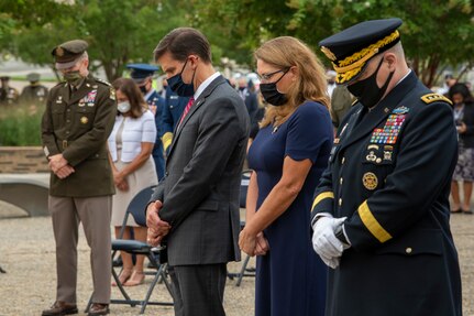 People stand and bow their heads.