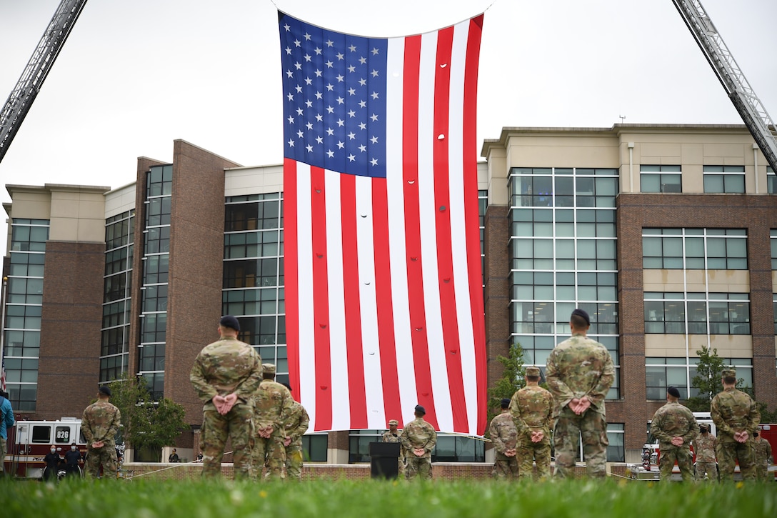 An American flag hangs between two fire trucks during the 9/11 remembrance ceremony at Heritage Park, Joint Base Andrews, Md., Sept. 11, 2020.