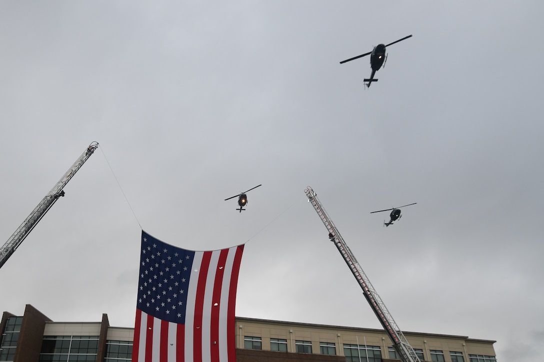 UH-1N helicopters from the 1st Helicopter Squadron fly over the flag during the 9/11 remembrance ceremony at Heritage Park, JBA, Md., Sept. 11, 2020.